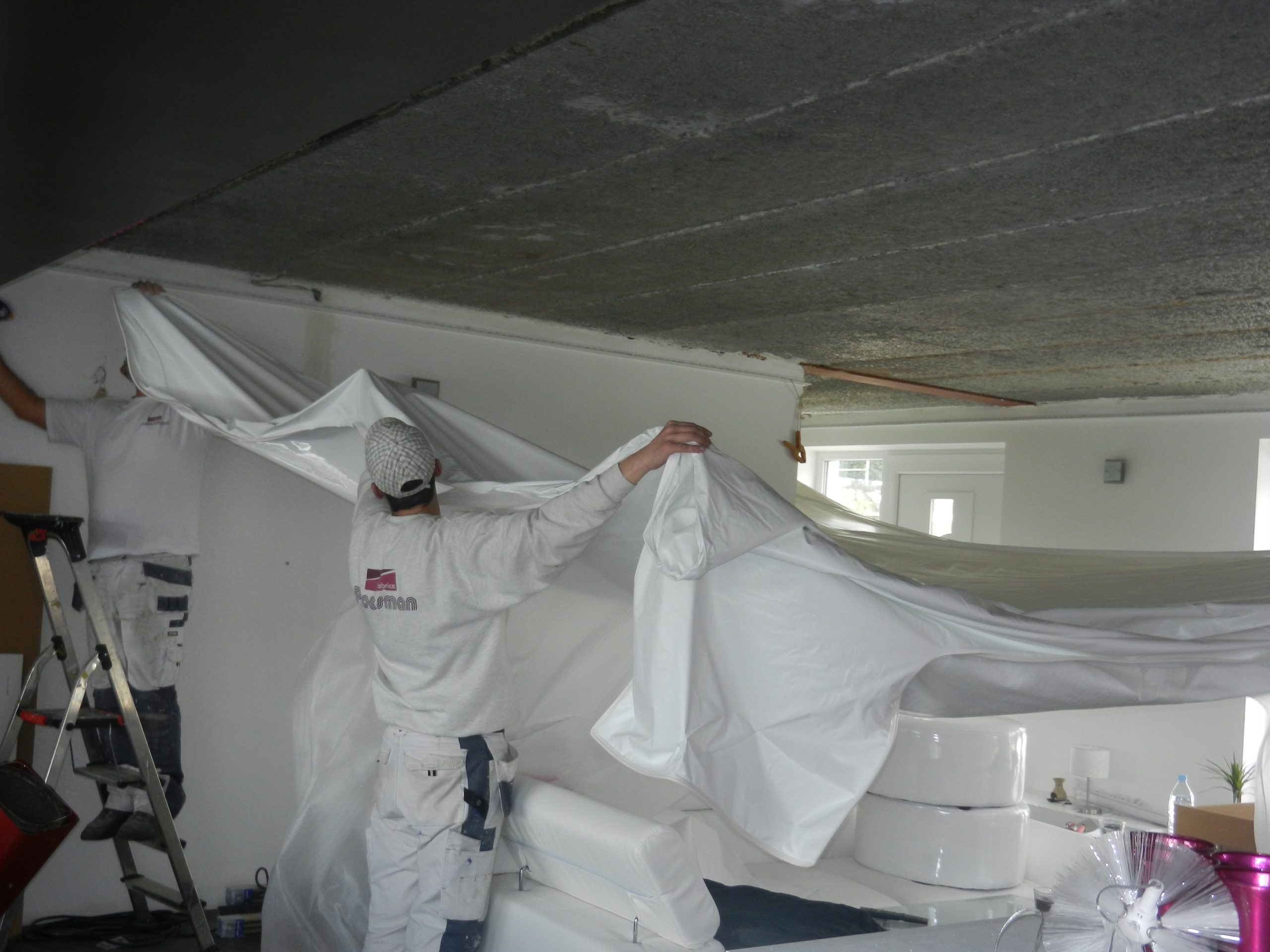 Peintre de Proesman Décoration qui protège le mobilier sous des bâches avant le chantier